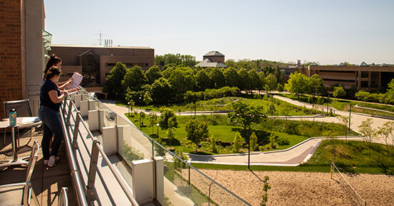 Two researchers observe and record site use on the University of Michigan North Campus